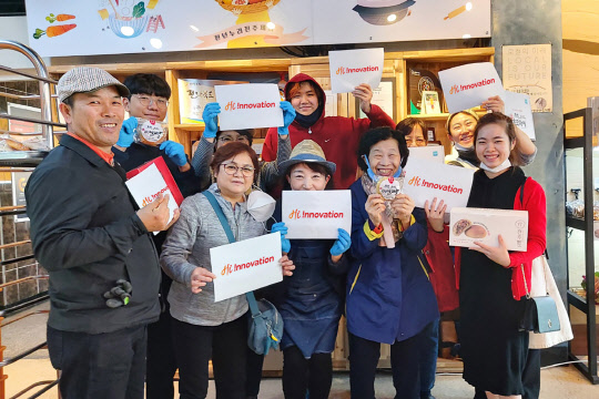 전주비빔빵 직원들이 SK이노베이션 통합 서브브랜드인 Hi !nnovation 로고를 들어보이고 있다.<SK이노베이션 제공>